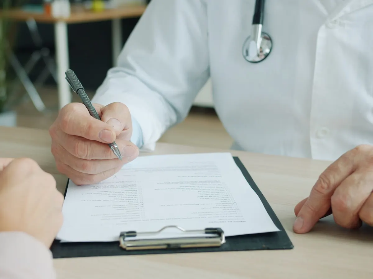 Médico entregando indicaciones por escrito a un paciente